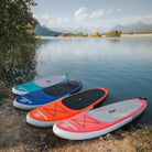 Synergy inflatable paddleboards in multiple colors displayed by a scenic lake view