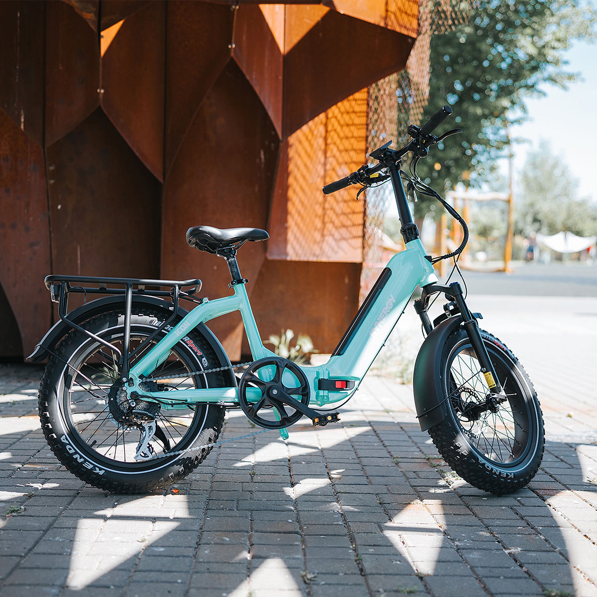 Turquoise Synergy low-step electric bike parked in a modern urban setting